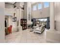 This beautiful living room boasts soaring ceilings, tiled floors, a fireplace, and large windows with backyard views at 2234 Callaway Ct, Davenport, FL 33837