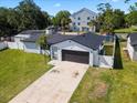 Aerial view of a single-story home featuring a long driveway and lush green lawn at 2506 Bali Cir, Kissimmee, FL 34741
