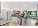Bright, open-concept kitchen with stainless steel appliances and a spacious island overlooking the living area at 2874 Turnstone Run, Harmony, FL 34773