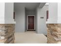 Close-up of the front door with stone pillars and neutral gray accents, a modern and inviting entrance at 2877 Fitness St, Clermont, FL 34714