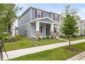Two-story home with a welcoming front yard, featuring a covered porch with stone accents and green landscaping at 2877 Fitness St, Clermont, FL 34714