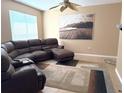 Spacious living room with a ceiling fan, neutral walls, a large window, and a plush leather sofa at 3561 Sanctuary Dr, St Cloud, FL 34769