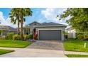 Inviting single-story home featuring a lush green lawn, mature landscaping, and a practical two-car garage at 4007 Green Sabal Dr, Orlando, FL 32824