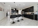 Modern kitchen featuring dark cabinets, granite countertops, a center island with seating, and stainless steel appliances at 4007 Green Sabal Dr, Orlando, FL 32824