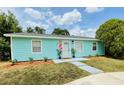 Inviting turquoise home with a tidy front lawn, complemented by tasteful landscaping at 4765 Lake Shore Dr, St Cloud, FL 34772