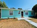 Light blue single-story home featuring a welcoming entrance and well-maintained front yard under a clear blue sky at 4765 Lake Shore Dr, St Cloud, FL 34772