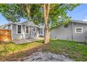 A peaceful backyard features a brick patio surrounded by lush greenery, great for entertaining and relaxation at 503 New York Ave, St Cloud, FL 34769