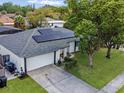 An aerial view of a single-story home featuring solar panels, manicured lawn and a two-car garage at 5123 Lighthouse Rd, Orlando, FL 32808