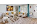 Bright living room featuring hardwood floors, neutral-toned sofas, and contemporary decor at 5123 Lighthouse Rd, Orlando, FL 32808