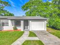 Single-story home featuring a well-maintained lawn, a welcoming front door, and an attached garage at 514 S Cottage Hill Rd, Orlando, FL 32805