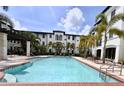 Inviting community pool surrounded by swaying palm trees and comfortable lounge chairs at 5550 E Michigan St # 2214, Orlando, FL 32822