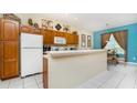 Functional kitchen with wood cabinetry, bright lighting, and a breakfast bar overlooking the dining area at 7719 Comrow St, Kissimmee, FL 34747