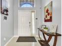 Bright foyer featuring tile flooring, high ceilings, and stylish decor, including a console table at 932 Emerald Green Ct, Kissimmee, FL 34746