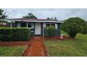 Cozy single-story home has front yard landscaping with trimmed shrubs and flower garden at 1617 Emmett St, Kissimmee, FL 34741
