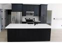 Modern kitchen with an island, stainless steel appliances and dark blue cabinets at 527 Stillwater Dr, Oviedo, FL 32765