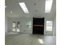 Spacious living room featuring skylights, a fireplace, and double doors at 527 Stillwater Dr, Oviedo, FL 32765