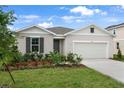 Charming single-story home boasts a manicured lawn and an attached two-car garage at 1126 Olivine Ave, Dundee, FL 33838