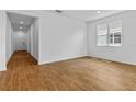 Bright living room featuring stylish wood-look floors and a large window at 1126 Olivine Ave, Dundee, FL 33838