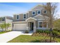 Two-story home with attached garage, neutral siding, stone accents, manicured lawn, and appealing curb appeal at 1690 Sugarbelle Cir, Mascotte, FL 34753