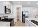 Bright kitchen featuring stainless steel appliances, white cabinets, an island, and a convenient pantry at 1690 Sugarbelle Cir, Mascotte, FL 34753