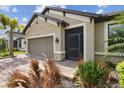 Charming home featuring a two-car garage, well-manicured lawn, and elegant exterior finishes at 204 Bella Cortina Dr, Poinciana, FL 34759