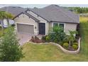 Inviting single-story home with a well-maintained lawn, paver driveway, and attached two-car garage at 204 Bella Cortina Dr, Poinciana, FL 34759