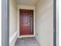 Inviting entryway features a stylish red front door with glass accents and brick flooring at 204 Bella Cortina Dr, Poinciana, FL 34759