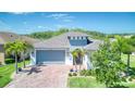 Inviting single-story home featuring lush landscaping, two-car garage, and brick paved driveway at 363 Bella Cortina Dr, Kissimmee, FL 34759