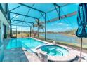 Screened-in pool and hot tub overlooking lake and manicured grounds creating a serene outdoor experience at 363 Bella Cortina Dr, Kissimmee, FL 34759