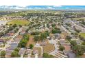 An aerial view showing a neighborhood with a variety of homes, trees, streets and a nearby pond at 7938 Riffle Ln, Orlando, FL 32818