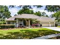 Beautiful single-story home boasts a well-manicured lawn, professional landscaping and a three-car garage at 9509 Baycliff Ct, Orlando, FL 32836