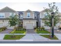 Picture of neutral townhomes with a one car garage, a paved driveway, and manicured landscaping at 1177 Seaside Mist Trl, Kissimmee, FL 34747