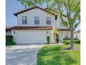 Charming home featuring a well-maintained lawn, two-car garage, and inviting entrance at 141 Summer Place Loop, Clermont, FL 34714