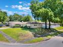 Exterior view of the home highlighting the manicured lawn, mature trees, and corner lot at 580 S Indigo Rd, Altamonte Springs, FL 32714