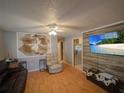 Cozy living room featuring wood-look floors, ceiling fan, and entertainment center at 629 N 7Th St, Lake Wales, FL 33853