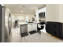 Modern kitchen featuring white cabinets, stainless steel appliances, and tiled floors at 6922 Doehring Dr, Lakeland, FL 33810