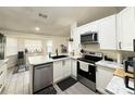 Modern kitchen featuring white cabinets, stainless steel appliances, and tiled floors at 6922 Doehring Dr, Lakeland, FL 33810