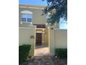 Close up of a 2 story tan stucco townhome with arched windows, red tile entry roof and brick walkway at 2550 Bella Vista Dr, Davenport, FL 33897