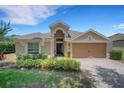 Inviting single-Gathering home featuring a well-manicured lawn and a brick driveway at 265 Del Sol Ave, Davenport, FL 33837