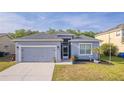 Charming single-Gathering home featuring a gray facade, attached garage, and well-manicured lawn at 3633 Bristol Cove Ln, St Cloud, FL 34772