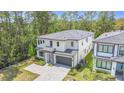 Contemporary two-story home with a two-car garage, gray roof, landscaping, and modern architecture at 1326 Butterfly Orchid Rd, Davenport, FL 33837