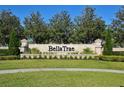 Inviting Bella Trae community sign with lush landscaping and a serene atmosphere at 1357 Venezia Ct # 202, Davenport, FL 33896