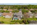 An aerial view of a screened-in pool in a neighborhood with green trees at 1559 Wescott Loop, Winter Springs, FL 32708