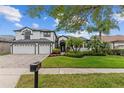 Charming curb appeal with a green lawn, mature palm trees, and colorful flowers at 1559 Wescott Loop, Winter Springs, FL 32708