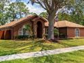 Beautiful one-story home featuring a manicured lawn, red door, stone accents, and an American flag at 20249 Macon Pkwy, Orlando, FL 32833