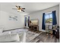 Well-lit living room with dark wood floors and entertainment area with TV and windows at 206 Bonville Dr, Davenport, FL 33897