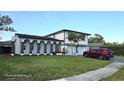 Charming two-story home with a lush lawn, complemented by mature landscaping at 2227 Coventry Dr, Winter Park, FL 32792