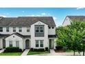 Beautiful two-story townhome showcasing a tile roof and vibrant landscaping against a blue sky at 228 Captiva Dr, Davenport, FL 33896