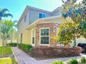 Side view of townhome with well-maintained landscaping and a brick paver walkway at 2305 Chatham Place Dr, Orlando, FL 32824