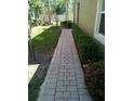 Manicured side yard with brick paver walkway and trimmed shrubs at 2305 Chatham Place Dr, Orlando, FL 32824